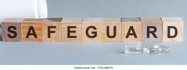 SAFEGUARD text on wooden table for your desing, coronavirus concept top view. Grey background. Safeguard word written on wood block, concept. - Shutterstock ID 1751188274