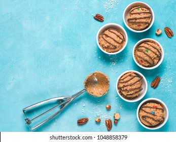 Safe-to-eat Raw Monster Cookie Dough In Small Portion Bowl, Ice Cream Scoop And Nuts On Blue Background. Ideas And Recipes For Kids And Toddlers Meal. Top View Or Flat-lay. Copy Space For Text.