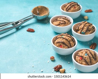 Safe-to-eat Raw Monster Cookie Dough In Small Portion Bowl, Ice Cream Scoop And Nuts On Blue Background. Ideas And Recipes For Kids And Toddlers Meal. Copy Space For Text.