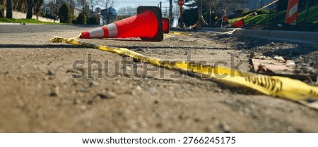 a safety barrier in disarray from heavy winds. caution tape on the ground