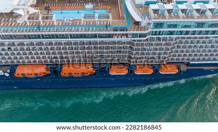 Safety equipment lifeboat. Orange lifeboat hanging over Sea on the side of a Cruise ship
