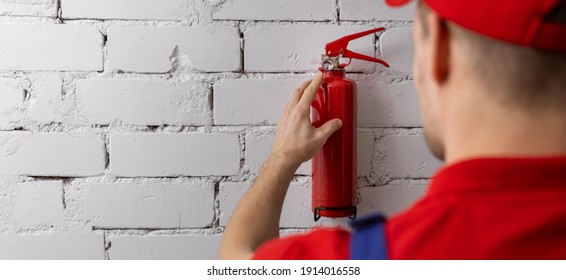 Safety Equipment Servicing And Maintenance - Service Worker Checking Fire Extinguisher Condition. Copy Space