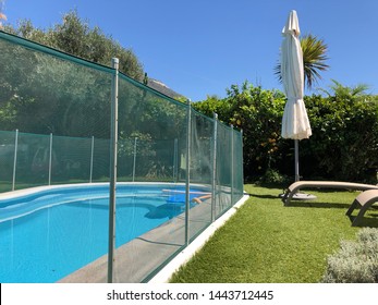 Safety fence around a small swimming pool in a back garden - Powered by Shutterstock