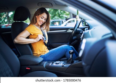 Safety First. Beautiful Female Driver Putting Seat Belt On Before Driving A Car.