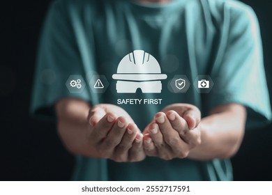 Safety first concept, work safety, caution work hazards, danger surveillance and zero accident. Person holding safety first symbols on virtual screen.