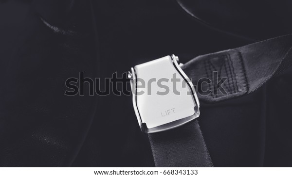 Safety first in plane and car
concept.Seat belt on passenger seat shot in airplane.Dark
tone.
