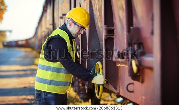 Safety first. Technician controls\
correctness of the freight car. Transportation\
concept