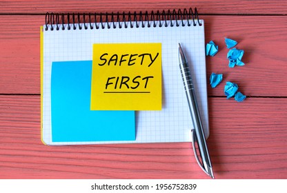 .SAFETY FIRST - Words On A Note Sheet On A Pink Background With A Pen. Info Concept