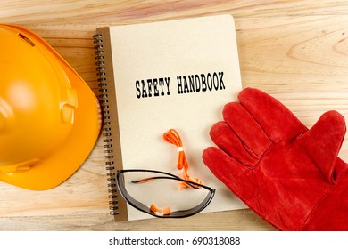 Safety Hat,glove,glasses,ear Plugs And Note Book With SAFETY HANDBOOK. Health And Safety Concept.