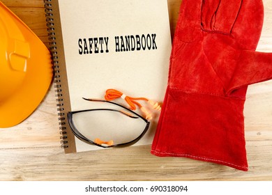 Safety Hat,glove,glasses,ear Plugs And Note Book With SAFETY HANDBOOK. Health And Safety Concept.