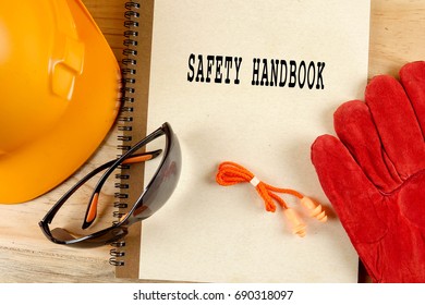 Safety Hat,glove,glasses,ear Plugs And Note Book With SAFETY HANDBOOK. Health And Safety Concept.