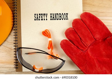 Safety Hat,glove,glasses,ear Plugs And Note Book With SAFETY HANDBOOK. Health And Safety Concept.