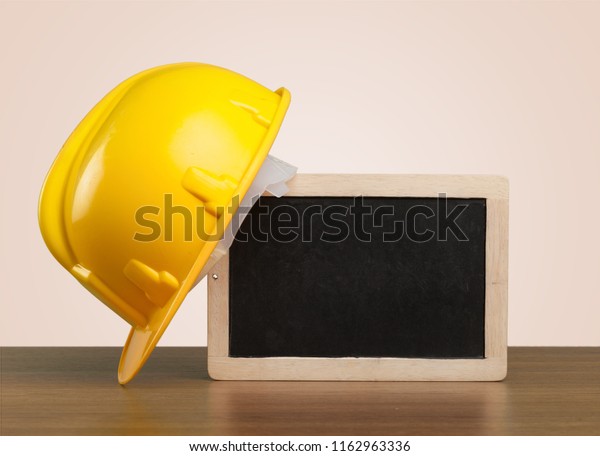 Safety helmet and white\
board with words Workplace Health and Safety,Health and Safety\
concept.