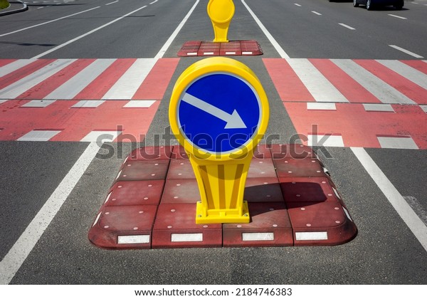 safety island with car traffic\
direction sign for auto, pedestrian crossing in the\
city