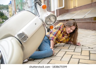 Safety Issues. A Woman Having Her Knee Injured While Falling From A Scooter