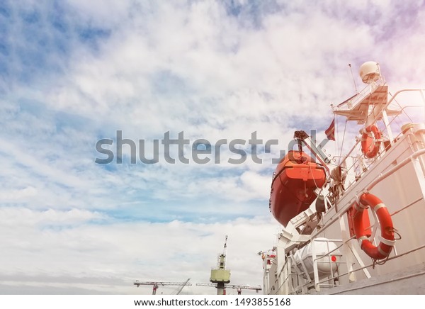 safety Lifeboat or rescue boat on deck of bulk\
ship near Life buoys, mast communication and navigation bridge deck\
during ship repair in shipyard\
