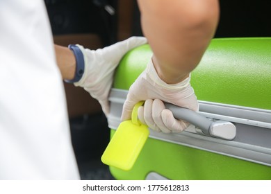 Safety Measures During Coronavirus, Hotel Employee  Wearing Protective Rubber Gloves To Take Suitcase From Car Trunk Before Disinfection.