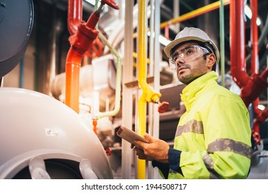 Safety Officer Checking Machine Giant Motor Modern Industrial Food Freeze Manufacturing Factory. Large Industry Caucasian White Wearing Safety Vest Take Note Maintenance Of Machines In The Factory.