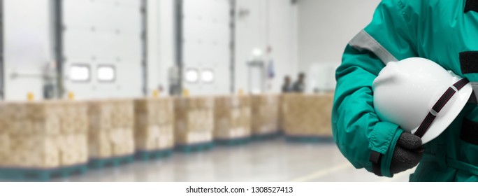 Safety Officer holding hardhat  for dangerous accident protection in warehouse during work. Cold room storage and freezing warehouse. Banners with copy space.
