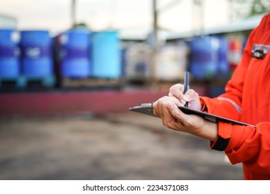 A safety officer is writing on the checklist document during safety audit workplace at the factory. Industrial expertise occupation working scene. Selective focus at hand's part - Powered by Shutterstock