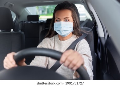 Safety And People Concept - Young Woman Or Female Driver In Medical Mask Driving Car In City