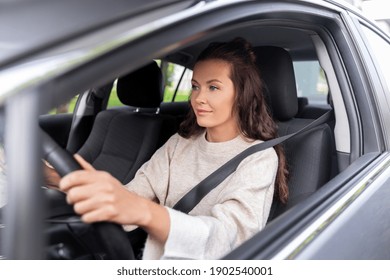 safety and people concept - young woman or female driver driving car in city