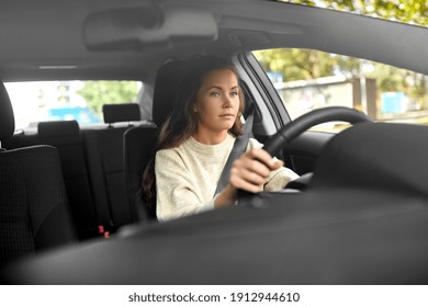 Safety And People Concept - Young Woman Or Female Driver Driving Car In City