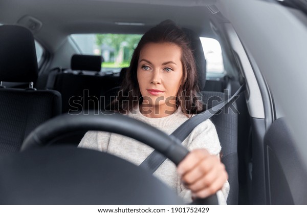 safety and people concept - young woman or female
driver driving car in
city