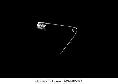 a safety pin isolated on a black background