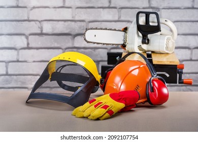 Safety Protective Equipment And Electric Saw On The Workplace. Personal Protective Equipment For Lamberjack.