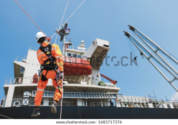 Safety rope access Demonstration, People\
worker sprinkle during ship repair in shipyard accommodation bridge\
deck background.
