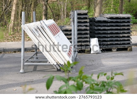 Safety and securing of a construction site: view of delivered traffic barriers and delineator posts with base plates, ready for installation, selective focus, copy space
