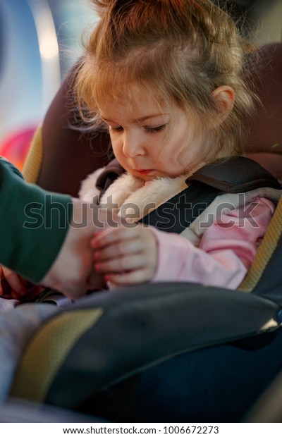 Safety and security -toddler girl sitting in the\
car seat\
