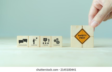 Safety Success In The Workplace Concept.  Hand Placed Wooden Cubes With Safety First Sign Standing With The Icon Of Communication, Leadership, Training And Compliance. Industrial Safety Banner. 