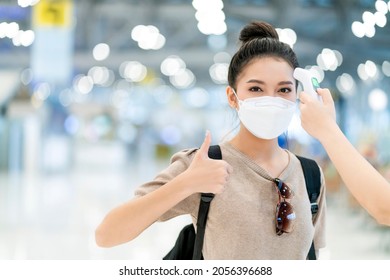 Safety Travel New Normal Lifestyle,asian Female Traveller Wear Casual Cloth Temperature Check Detect Covid-19 At Airport Terminal Before Going Abroad Travel With Blur Airport Departure Terminal