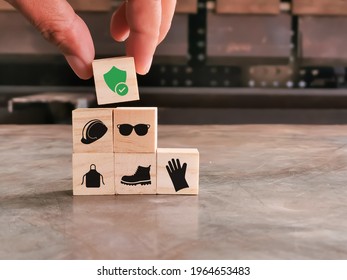 Safety at work concept. Hand putting wooden block with safety icons.