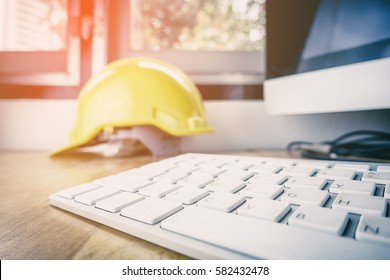 Safety Work In Industrial And Factory Concept. Engineer Construction Safety Hat Helmet On Office Working Desk With Desktop Computer.