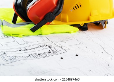 Safety Work Protective Accessories, Occupational Safety And Health In Construction, Worker's Uniform, Against The Background Of Architectural Drawings With Copy Space