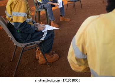 Safety Workplace Clear Pic Of Construction Worker Setting On The Chair Maintains 1.5 Metre Social Distancing Prevention Of Coronavirus -19 During Prestating, Signing Off Paperwork Risk Assessment 