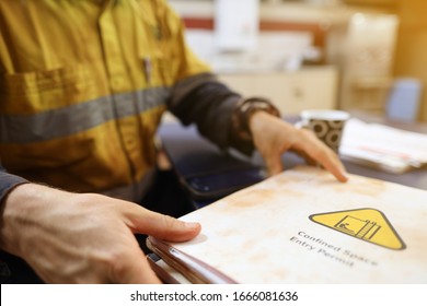 Safety Workplace Defocused Of Construction Worker Holding Confined Space Permit Book Paper Prior Starting Job 