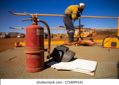 Safety Workplace Hot Work Permit Book, Welding Dark Mask Face Shield Eyes Safety Protection Fire Extinguisher Placing On The Steel Platform With Defocused Welder Conducting Welding Repairing Handrail 