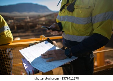 Safety Workplace Miner Supervisor Checking Site Emergency Phone Number Before Sigh Of Confined Space Permit Prior To Performing High Risk Work On Construction Mine Site, Perth, Australia 