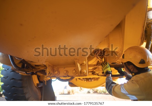 Safety workplace pre\
operation checklist motor vehicle mechanic inspector wearing safety\
helmet inspecting haul truck hydraulic power hose connection  prior\
work each shift 