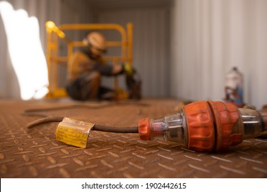 Safety Workplaces Approved Pass Test Tag Of Electrical Device Attached On Power Cord While Defocused Worker Using Power Drill On Construction Site 