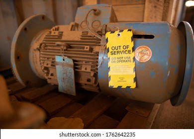 Safety workplaces yellow out of service tag attached on faulty damage defect of electric power motor. 