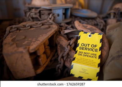 Safety Workplaces Yellow Out Of Service Warning Tag Attached On Faulty Damage Defect Of Industry Heavy Duty Lifting Chains Block At Construction Site Perth, Australia