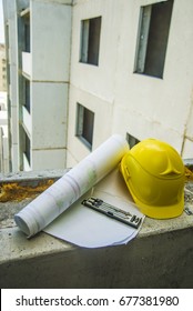 Safety Yellow Helmet Blue Print Plan, Compass And Construction Equipment On Engineer Working Table With Building Construction Background Use For Real Estate And Land Development Theme