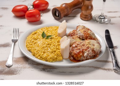 Saffron Risotto With Parmigiana Steak Beef. Risoto And Beef In A White Plate On Wooden White Background. Soft Light, Angle View. Italian Food. Risotto With Curcuma