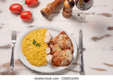 Saffron Risotto With Parmigiana Steak Beef. Risoto And Beef In A White Plate On Wooden White Background. Soft Light, Top View. Italian Food. Risotto With Curcuma