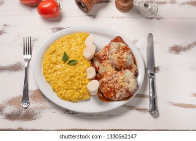 Saffron Risotto With Parmigiana Steak Beef. Risoto And Beef In A White Plate On Wooden White Background. Soft Light, Top View. Italian Food. Risotto With Curcuma